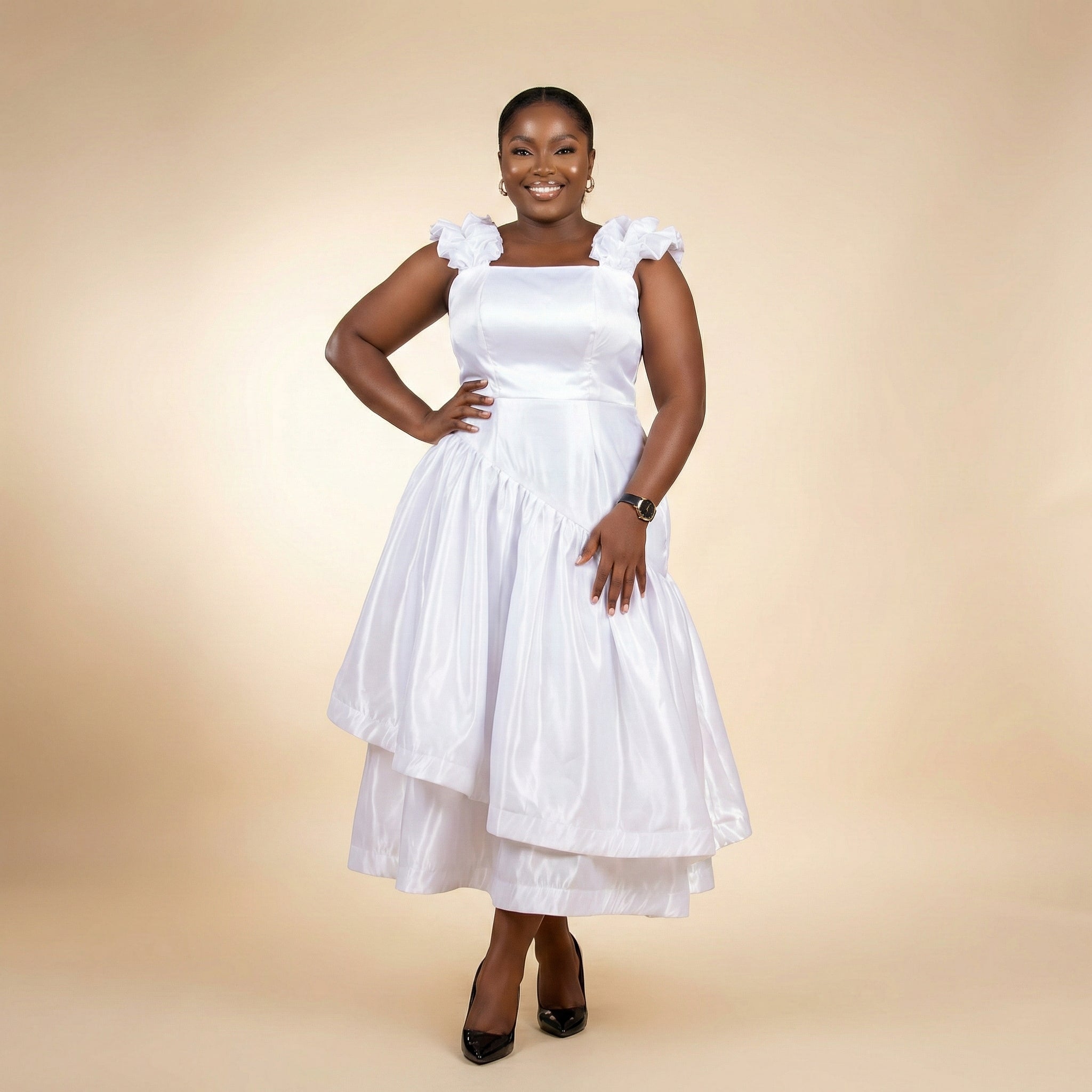 Woman wearing a white dress with ruffled sleeves on a beige background, ready to wear